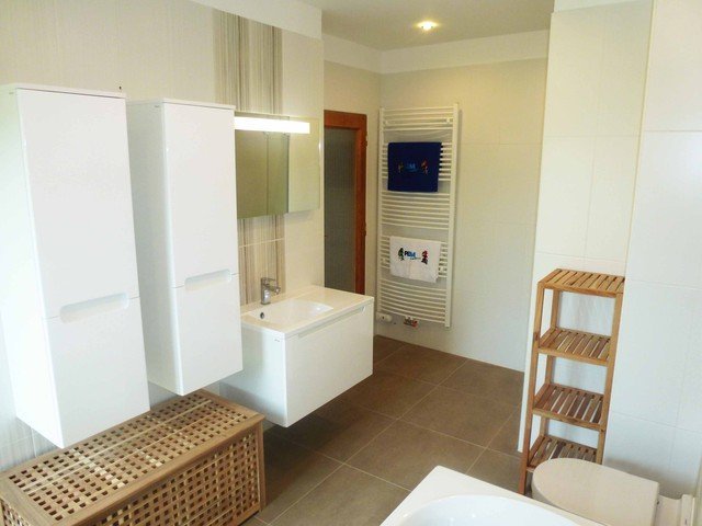 Rekonstrukce koupelny - decentní světlé obklady, koupelnový nábytek Ravak v bílé barvě a další dřevěné úložné prostory vytváří moderní a zároveň útulný prostor | Litomyšl