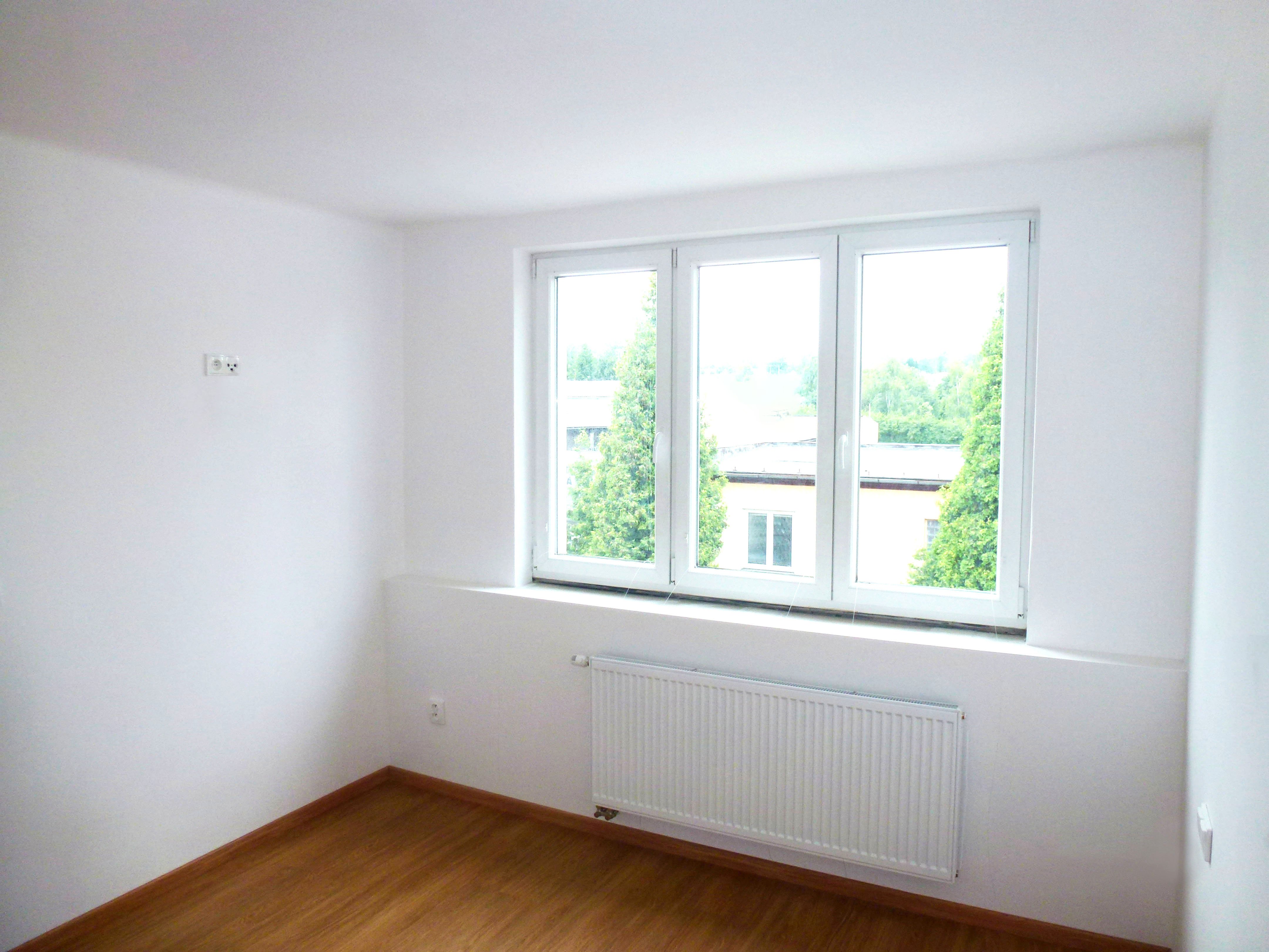 Ložnice v bílé klasice s podlahou v dřevěném dekoru_rekonstrukce bytu 2+kk | Koupelny-svitavy.cz